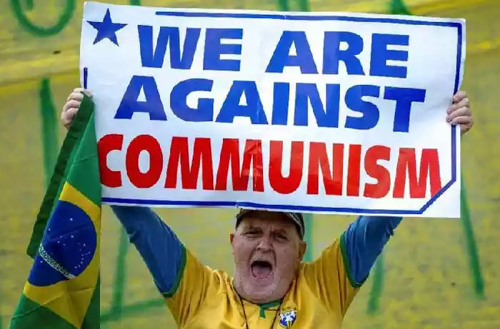Manifestante segura cartaz com frase em ingls 'ns somos contra o comunismo' em So Jos dos Campos, interior de SP